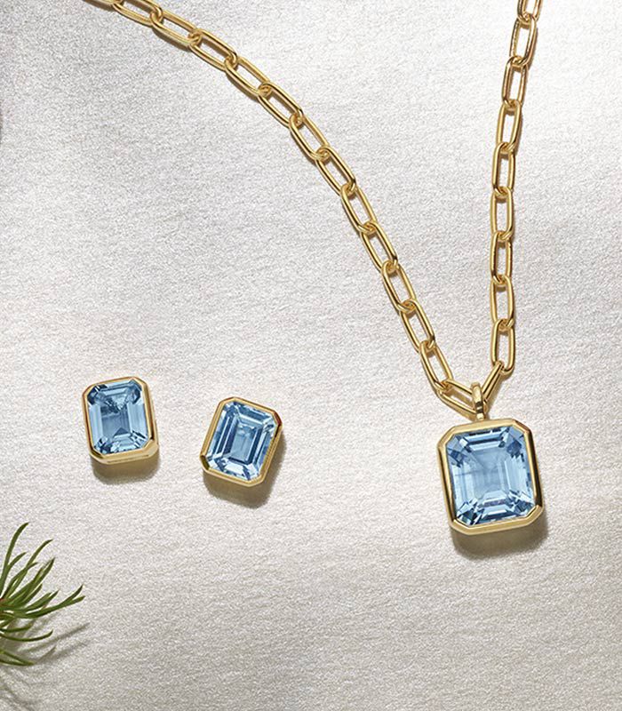 A pair of blue topaz earrings and matching pendant