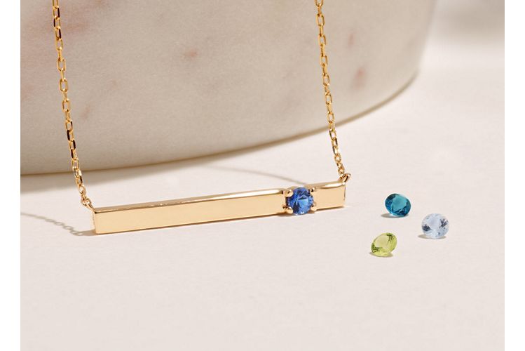 Mobile image of A collection of gemstones with a gold bar necklace