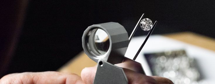 Person Using Magnifier To Check Clarity of A Round Diamond