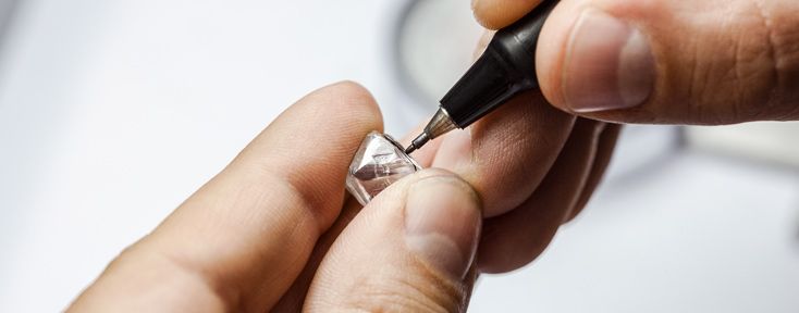 Close Up of Hands Holding Loose Diamond and Tool