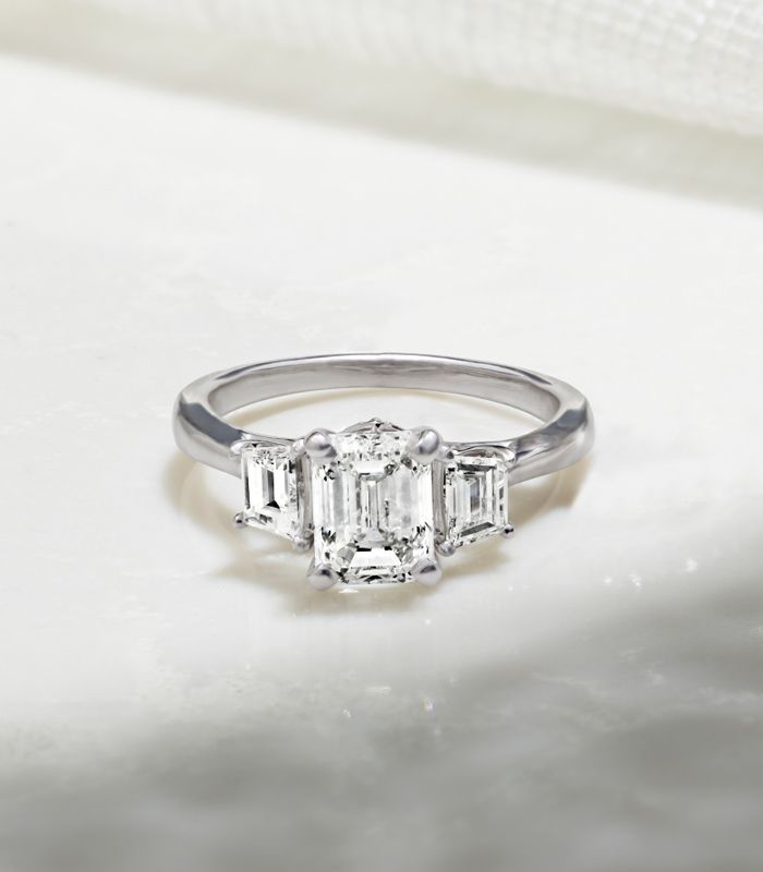 A Cathedral Engagement Ring Sitting on Flat Surface