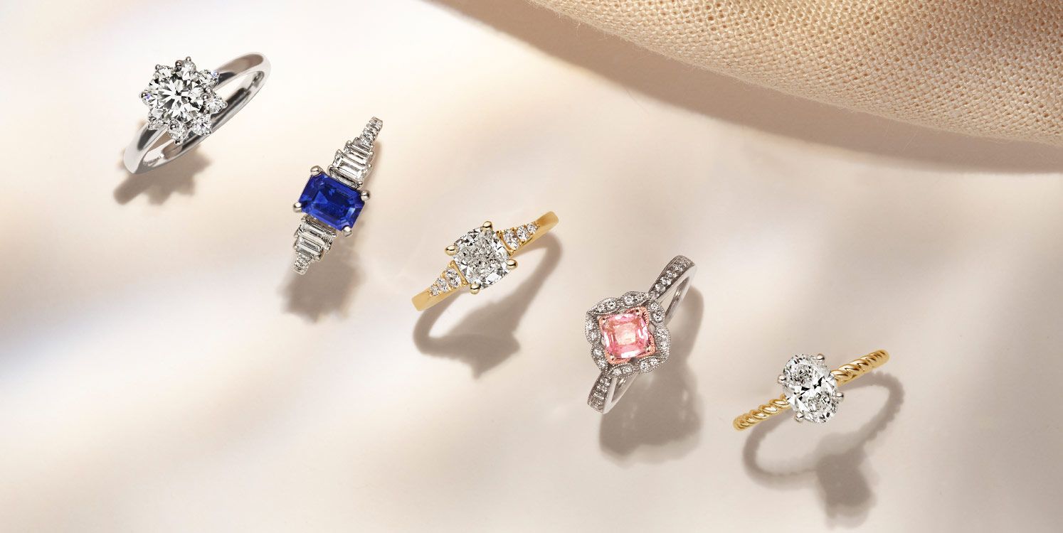 A collection of engagement rings with colored gemstone center stones