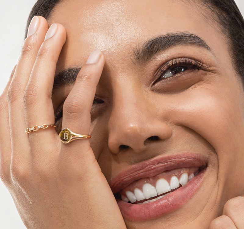 A woman wearing an engraved signet ring