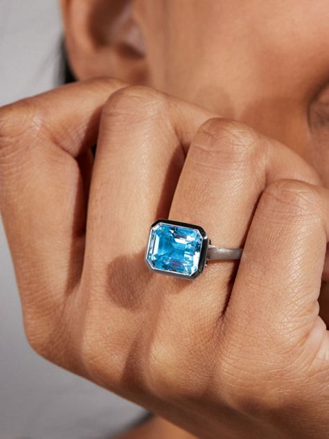 A woman wearing a blue gemstone fashion ring