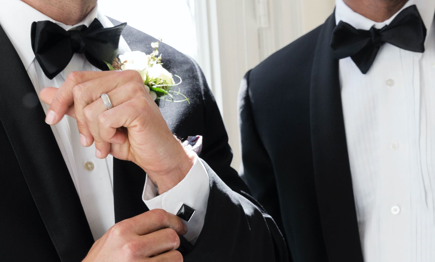 A man adjusting his cufflink on his wedding day