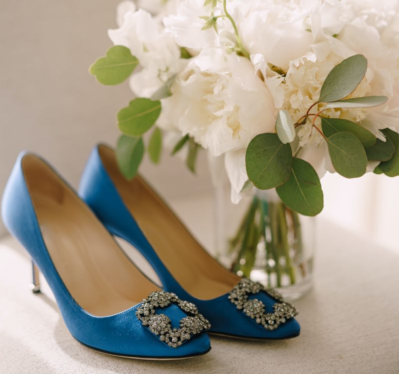 A pair of heels and a vase of flowers