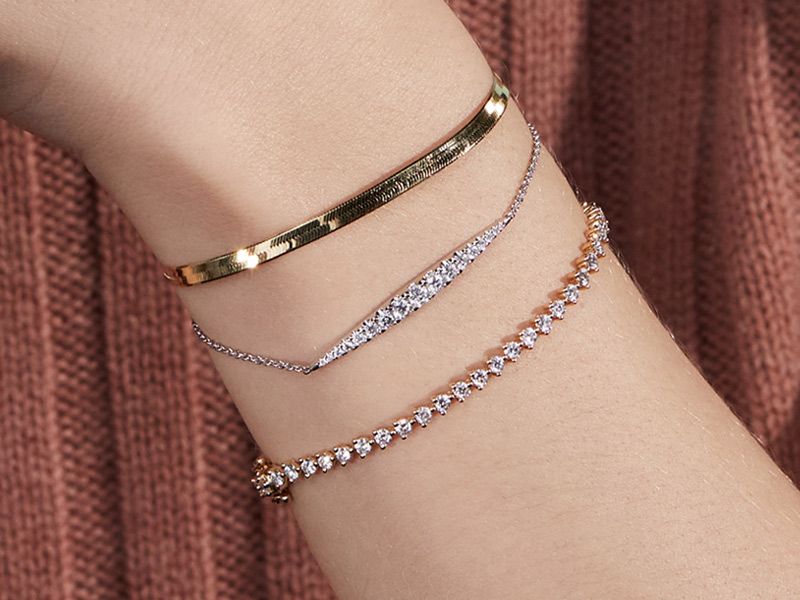 Woman wearing two gold bracelets