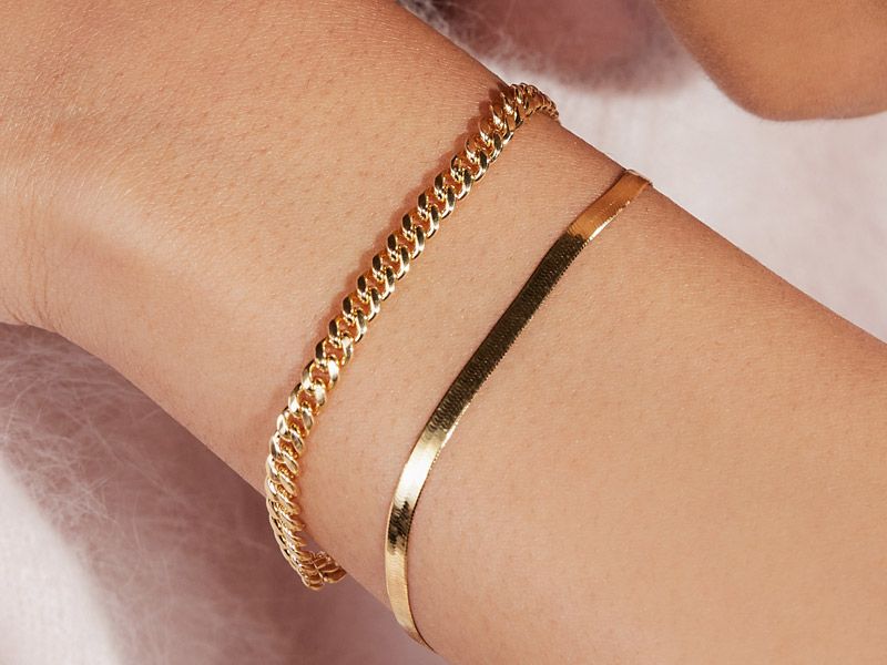 Woman wearing two gold bracelets