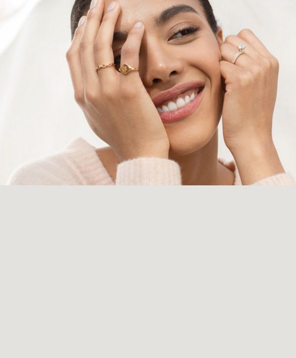 Mobile Image of a woman wearing a collection of fashion rings