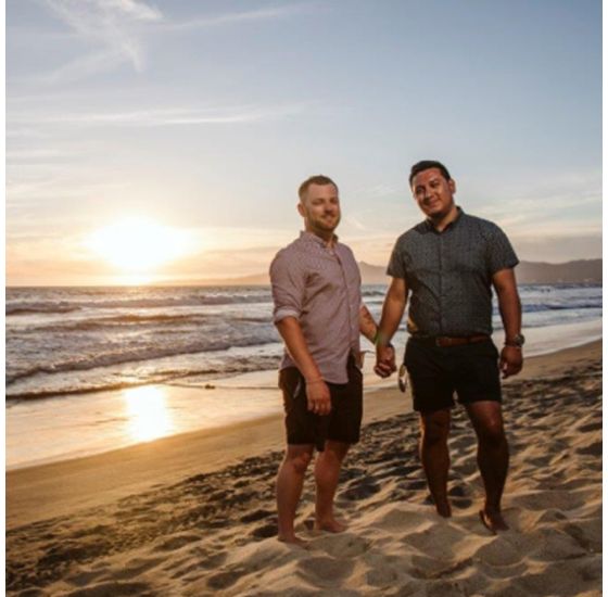 A couple standing on a beach holding hands