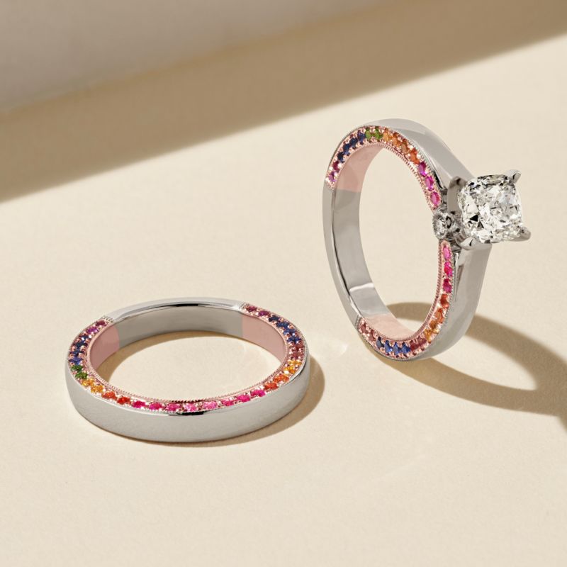 An engagement ring and matching wedding band with rainbow gemstones
