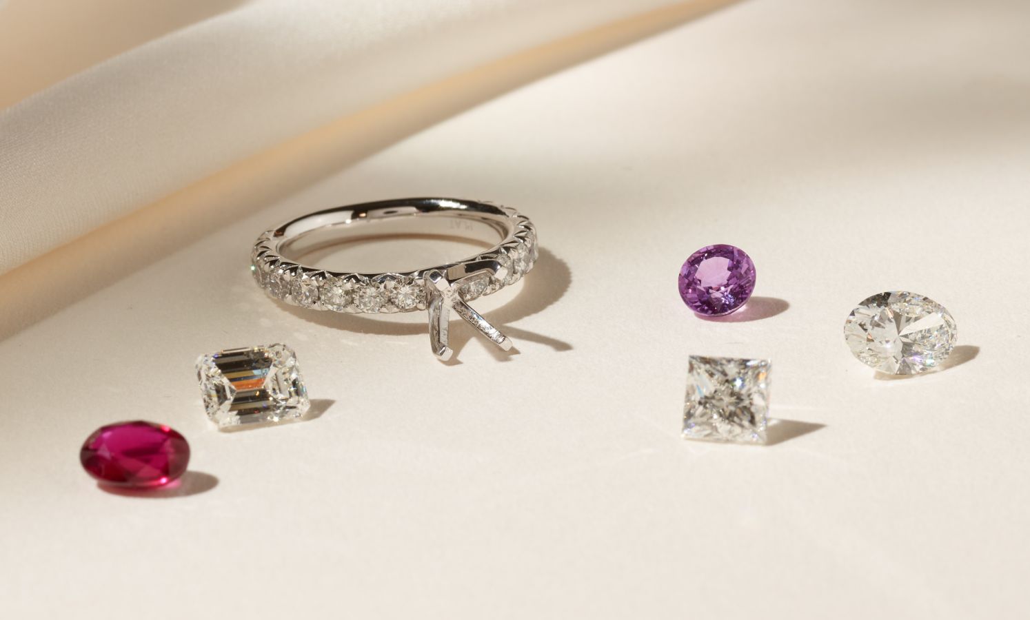 An engagement ring surrounded by loose gemstones