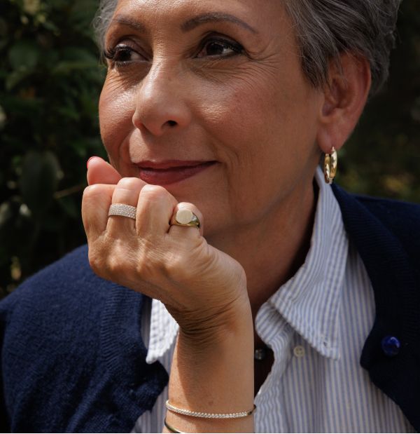 Woman resting her chin on her hand earing fine jewelry