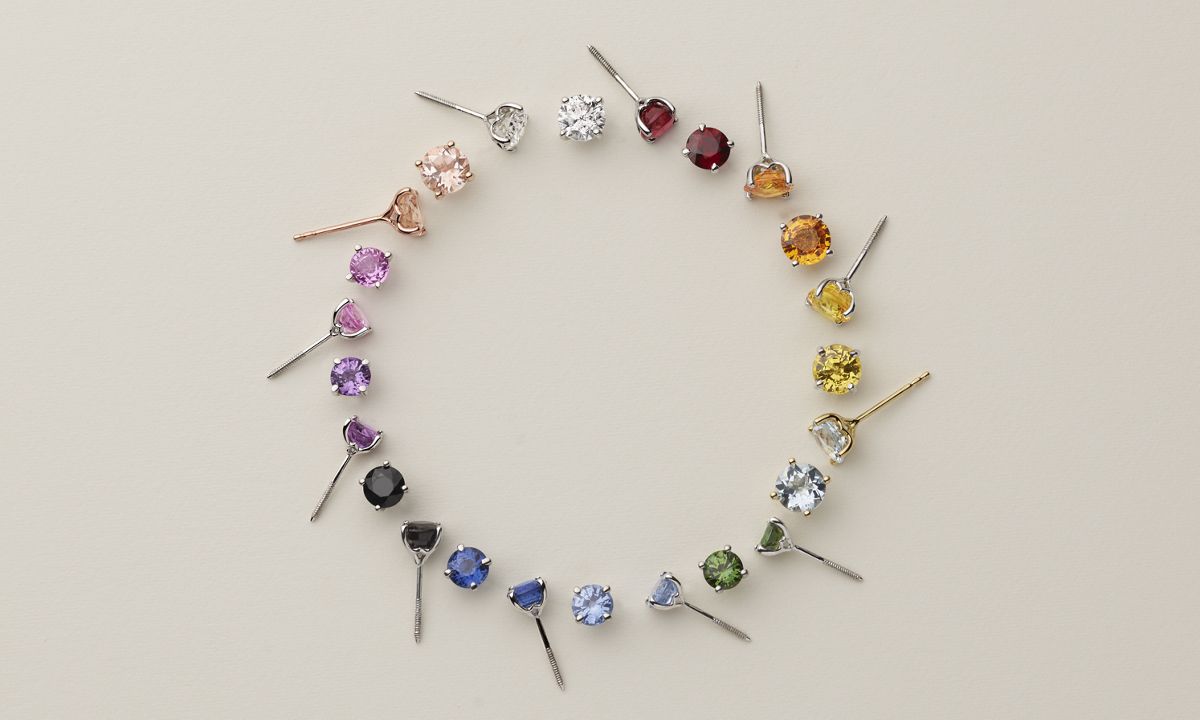 A circular rainbow of colorful stud earrings