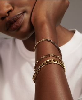 A woman wearing a collection of fashion bracelets