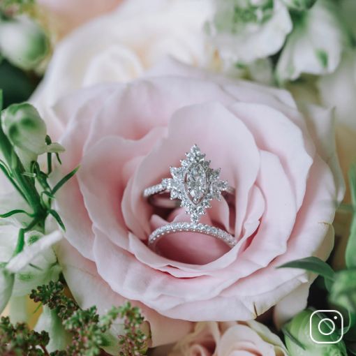 A diamond engagement ring and wedding band inside of a flower