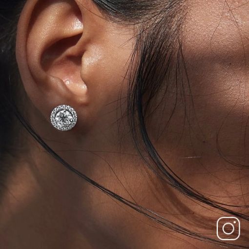 A woman's ear showing off a pair of diamond earrings