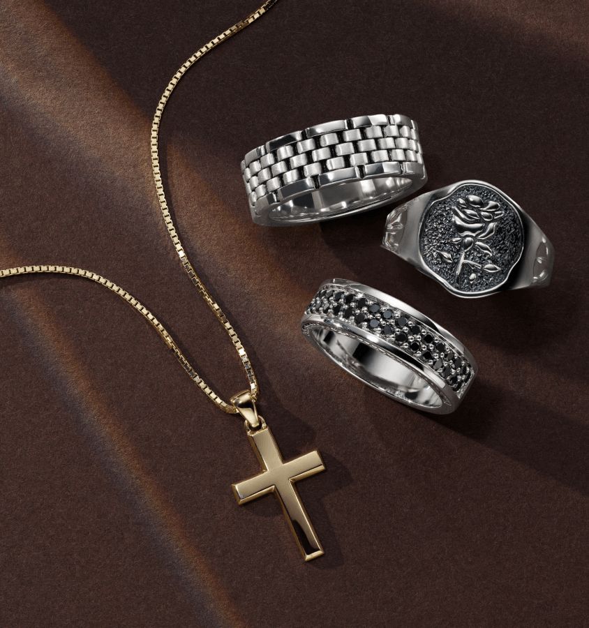 A collection of men's rings and a cross necklace