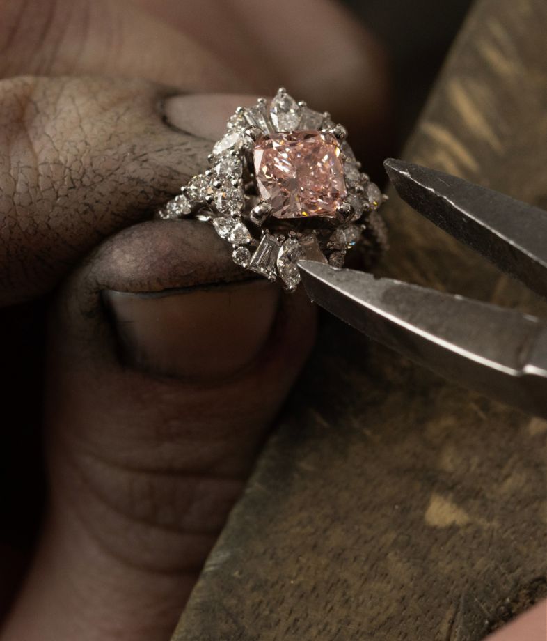 A jeweler setting a diamond center stone into an engagement ring