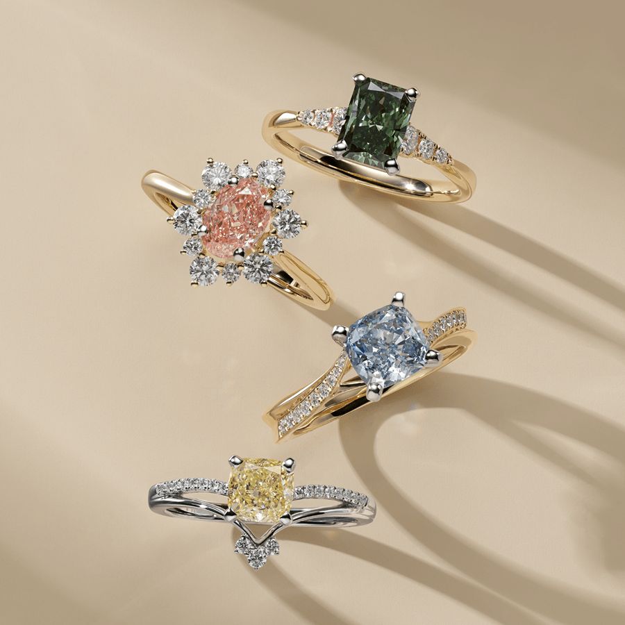 Four engagement rings with different colored lab grown center diamonds.