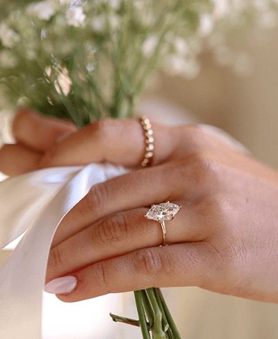 A woman's hand showing off a marquise lab grown diamond engagement ring.