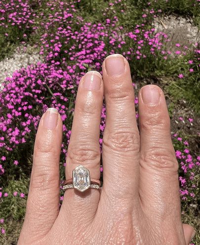 A woman showing off an engagement ring and wedding band set