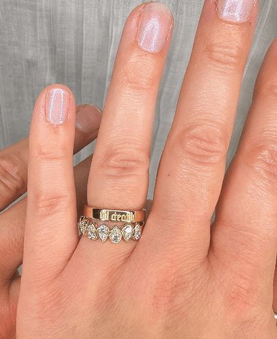 A woman's hand showing two bands stacked on her finger
