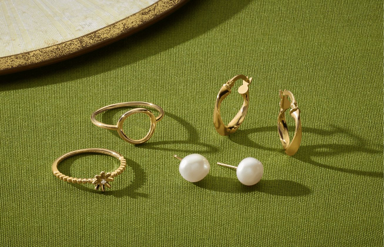 A collection of holiday jewelry on a green background