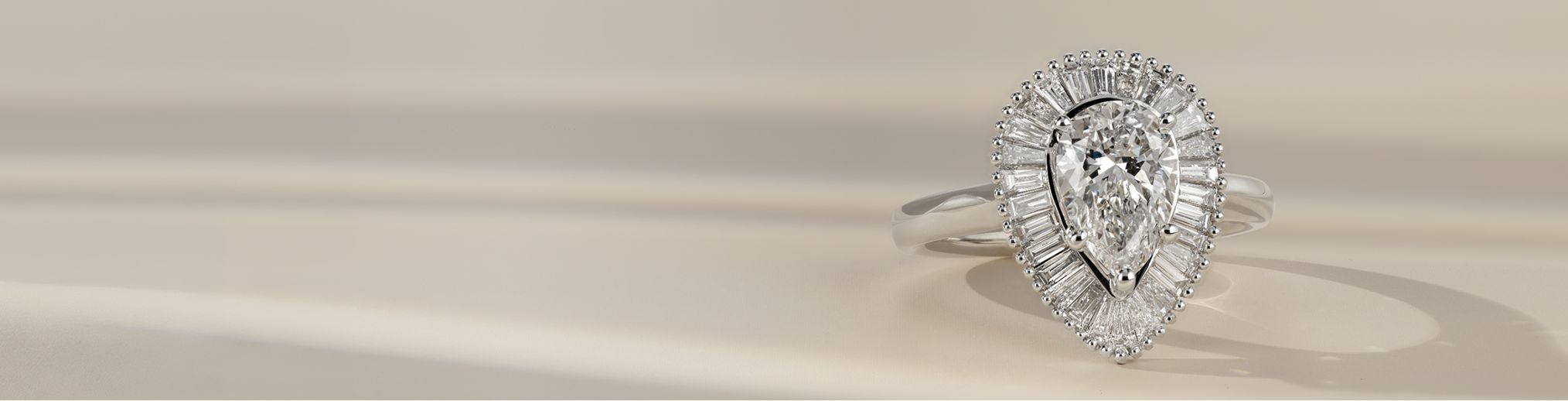 A diamond engagement ring with a pear shaped center diamond
