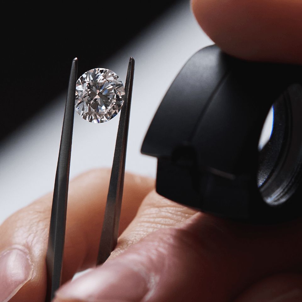 A jeweler viewing a loose diamond through a jewelers loupe
