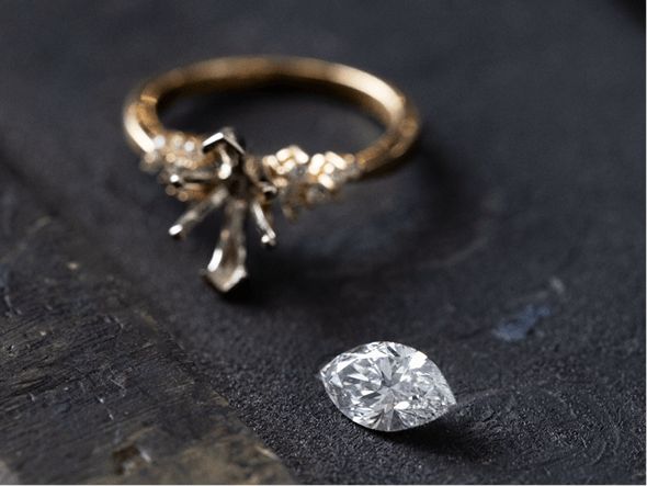 An engagement ring setting with a marquise loose diamond next to it