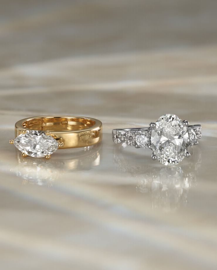 Two diamond engagement rings sitting next to each other