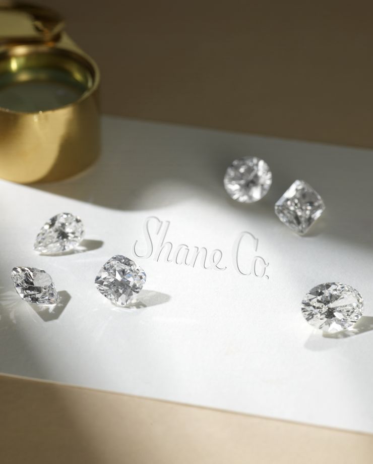 Different shaped loose diamonds sitting on a table