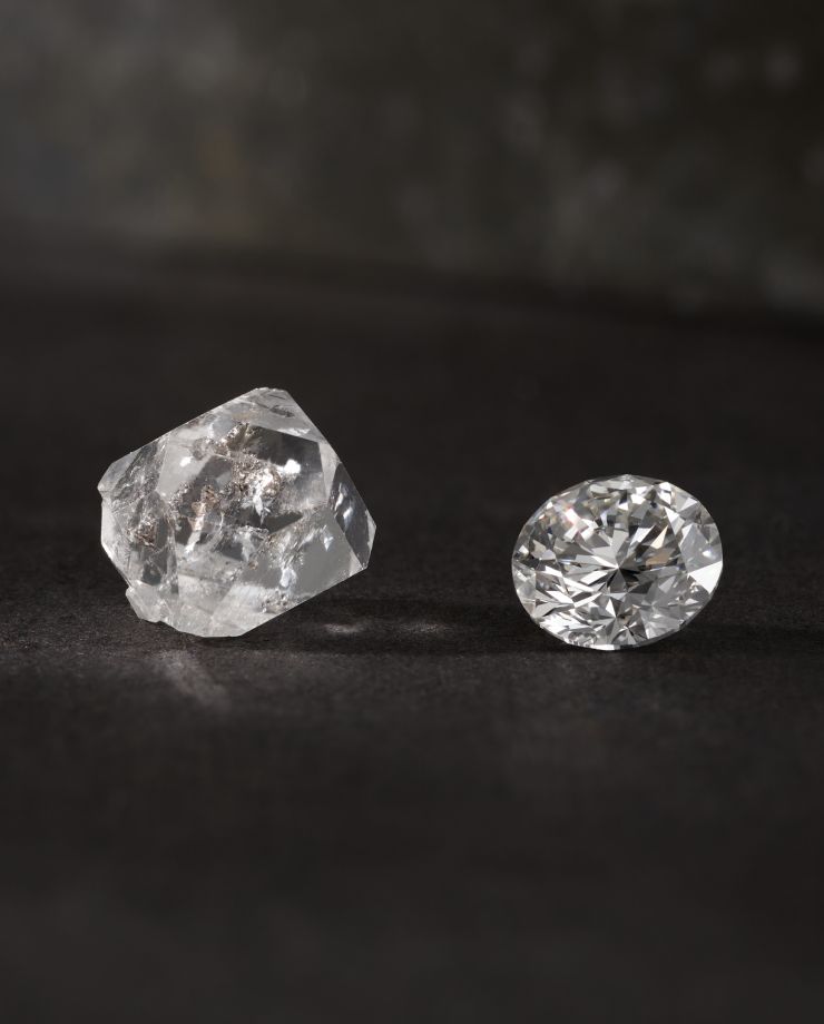 A cut diamond next to a raw diamond