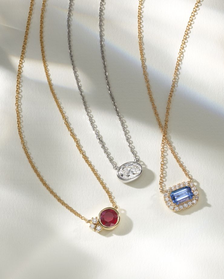 Three different styles of necklaces with colored center stones