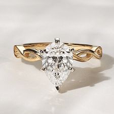 An infinity engagement ring with a pear center stone