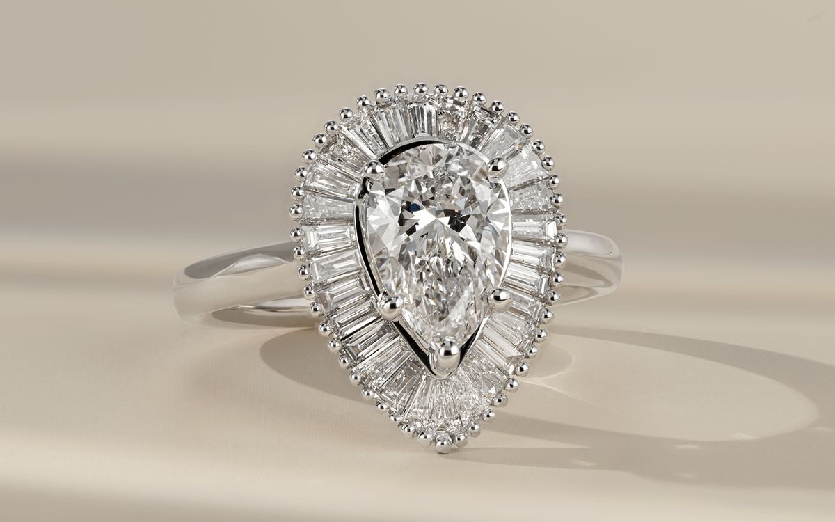 A vintage inspired diamond engagement ring with a pear center stone