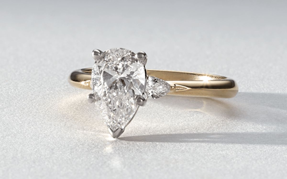 A classic diamond engagement ring with a pear center stone