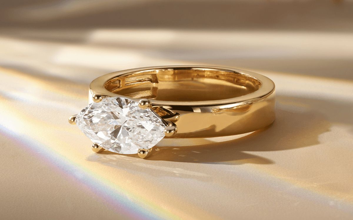 An east-west set diamond engagement ring with a marquise center stone