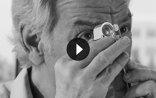 Tom Shane looking through a jewelers loupe at a loose diamond