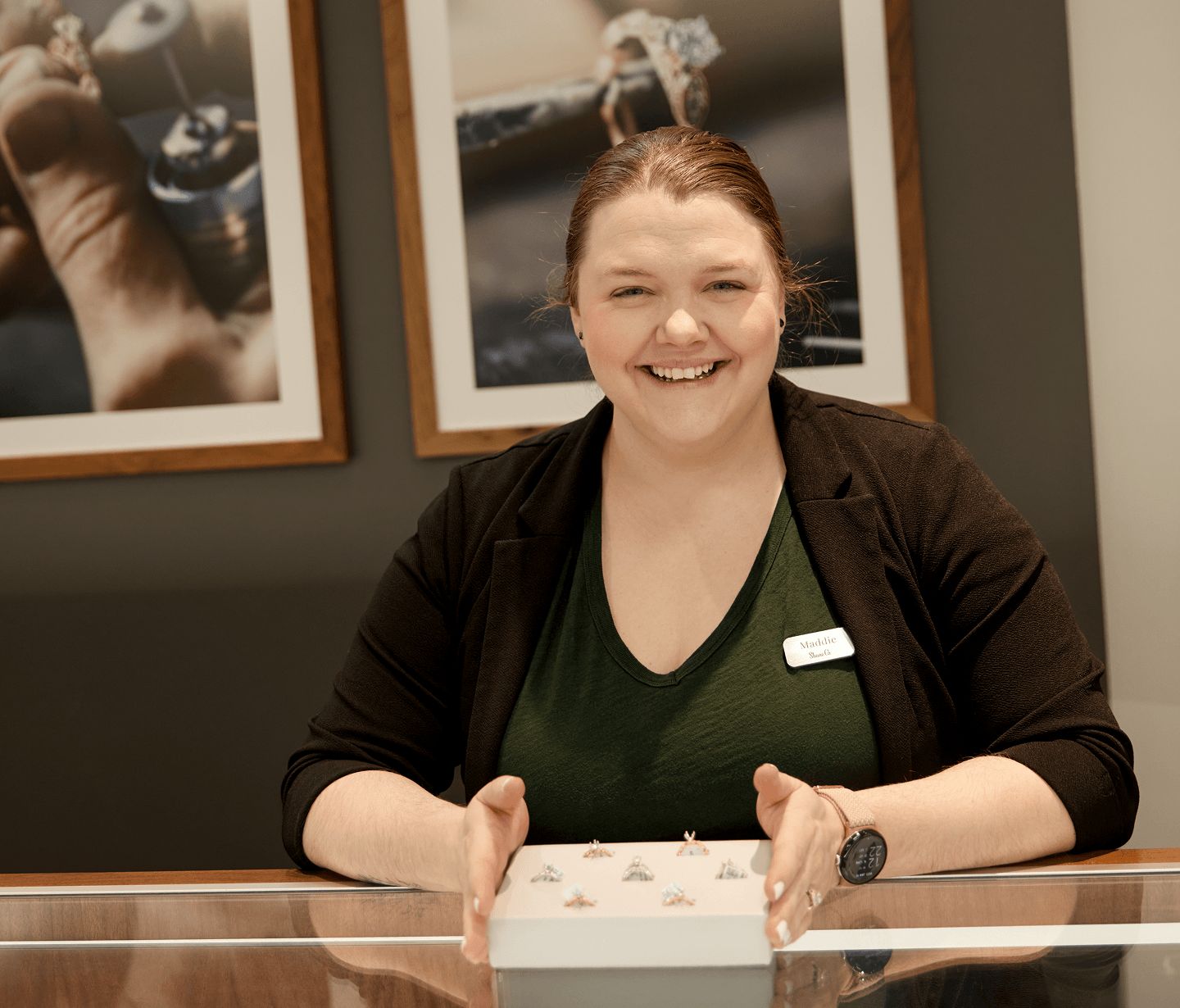 A jewelry consultant showing a display of diamond engagement ring settings
