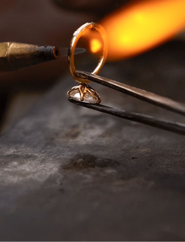 A jewelers torch working on a diamond engagement ring