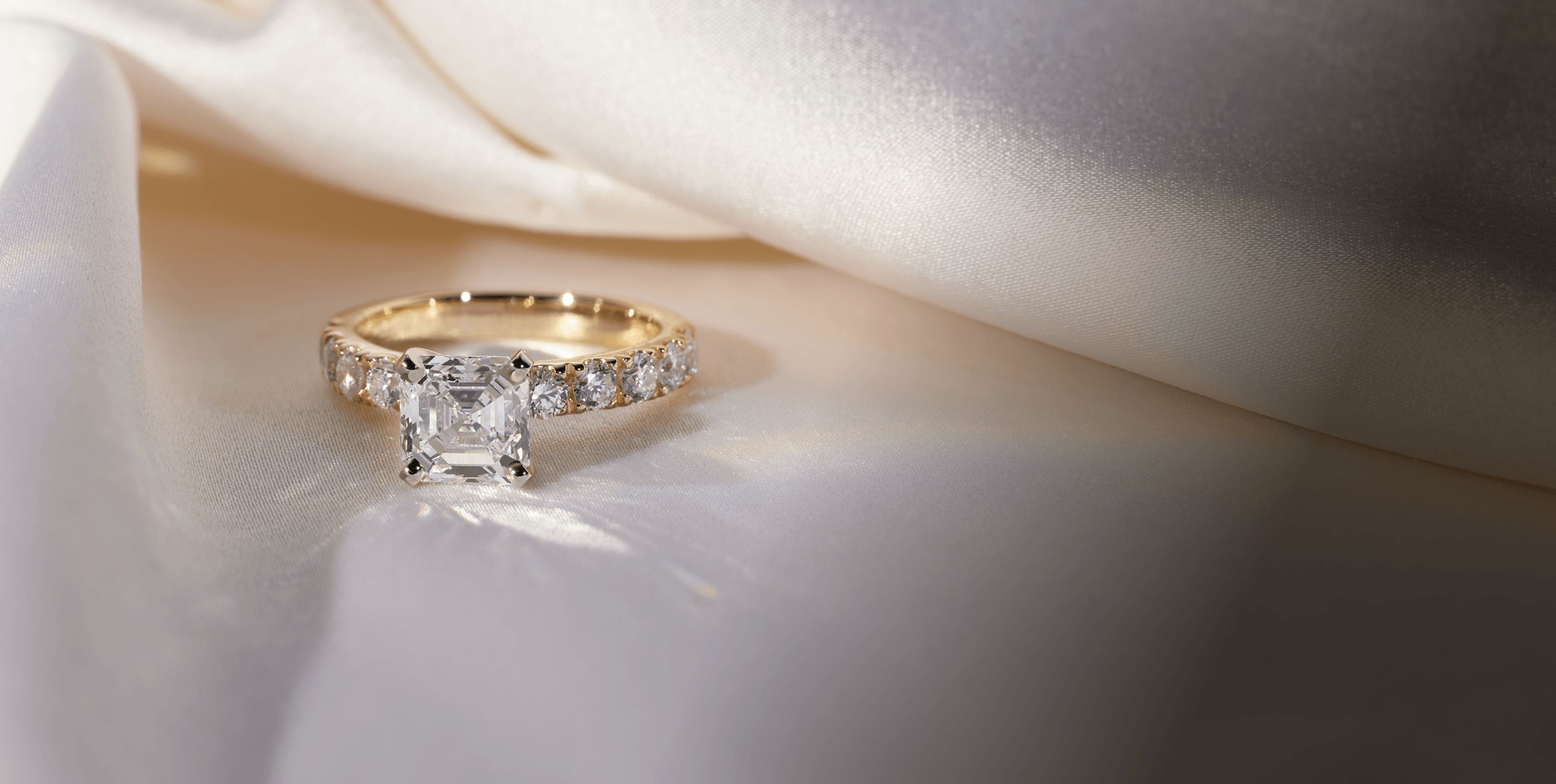 A diamond engagement ring surrounded by white cloth