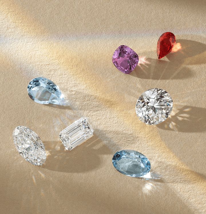 A collection of loose diamonds and colored gemstones of different shapes