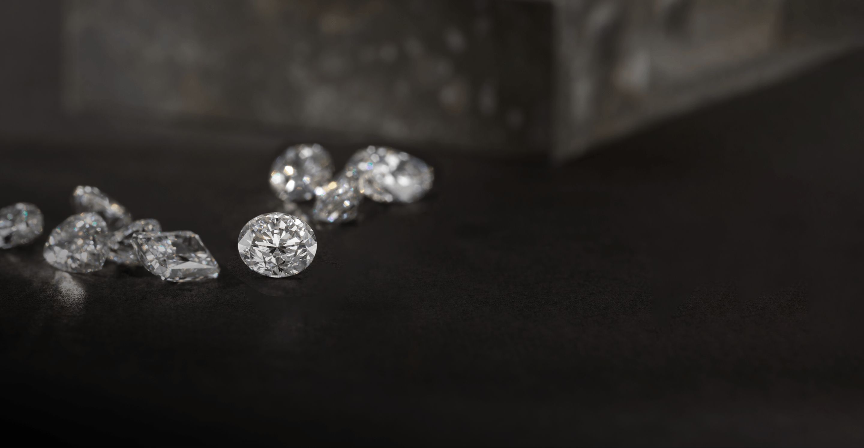 Loose diamonds laying on a dark table top