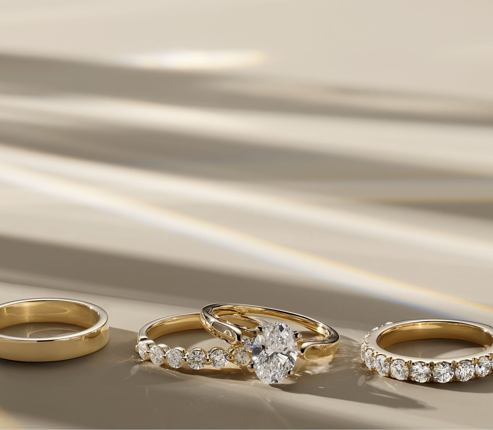 A plain wedding band, a diamond engagement ring wedding set and a diamond wedding band all sitting next to each other