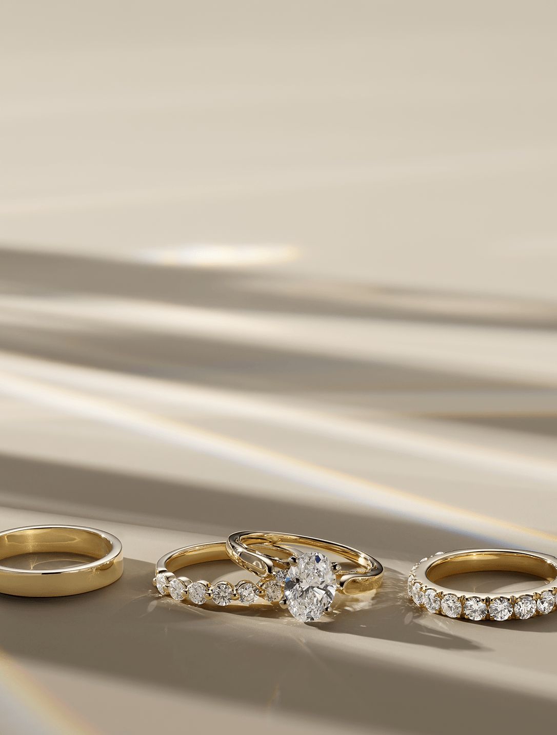 A plain wedding band, a diamond engagement ring wedding set and a diamond wedding band all sitting next to each other