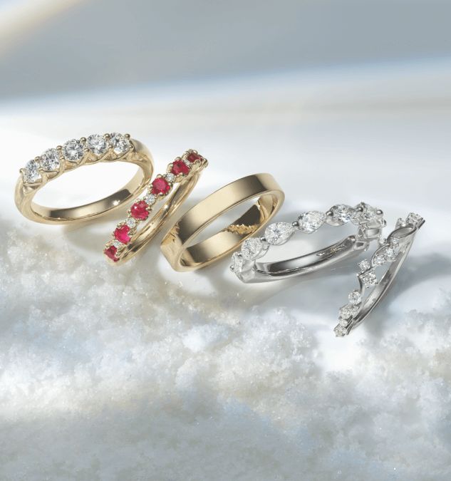 A group of 4 wedding bands surrounded by snow