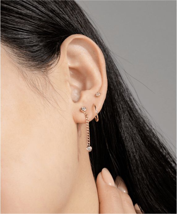 A woman wearing multiple styles of fashion earrings