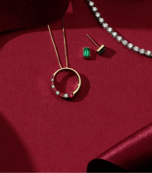 A collection of holiday jewelry on a red background